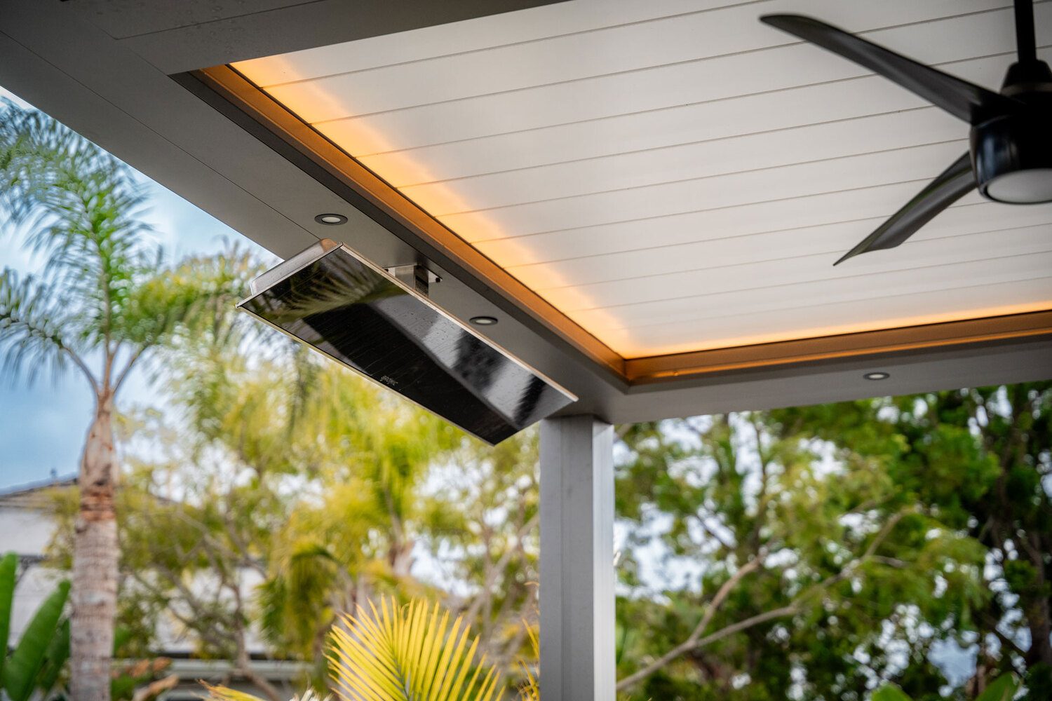Outdoor ceiling heater under patio roof with fan and garden view by Portland Window Coverings in Tigard, OR